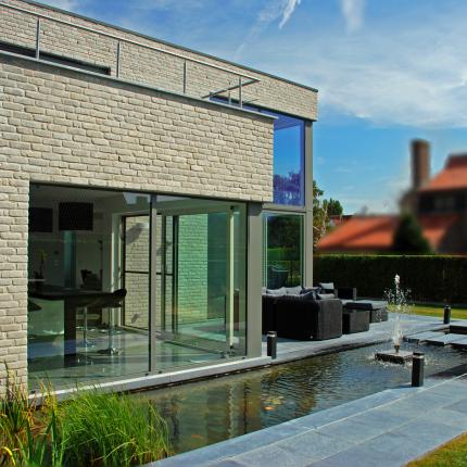 Achtergevel moderne villa in gevelsteen met waterpartij