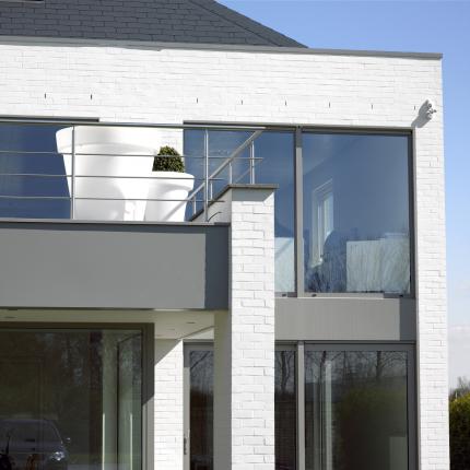 Detail achtergevel hedendaagse ruime koppelwoning in wit geschilderde gevelsteen