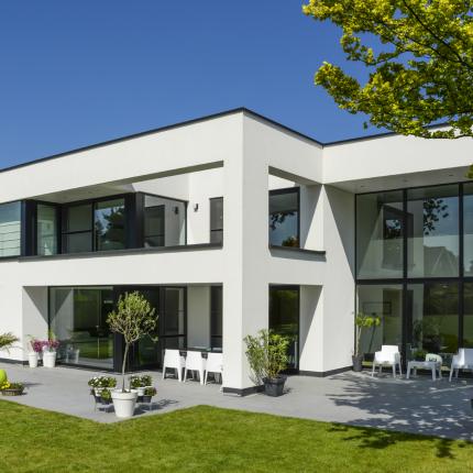 Achtergevel villa met eenvoudige volumespel in witte crepi