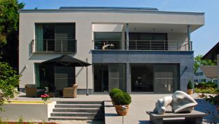 Achtergevel met aangelegd terras en waterpartij