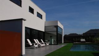 moderne villa in crepi met grote glaspartijen achteraan