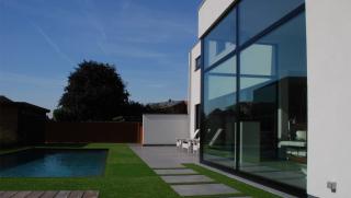 moderne villa in crepi met grote glaspartijen achteraan