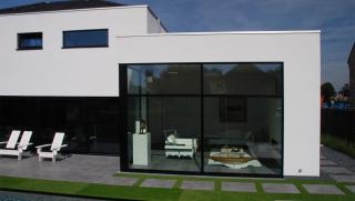 moderne villa in crepi met grote glaspartijen achteraan