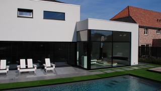 moderne villa in crepi met grote glaspartijen achteraan